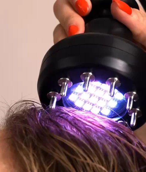 Brosse à lumière LED posée sur le cuir chevelu pendant le Spa Coréen